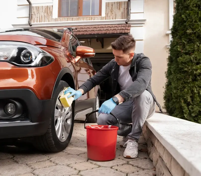 Lavage auto à domicile Saint-Clément-les-Places : professionnel intervenant sur un véhicule